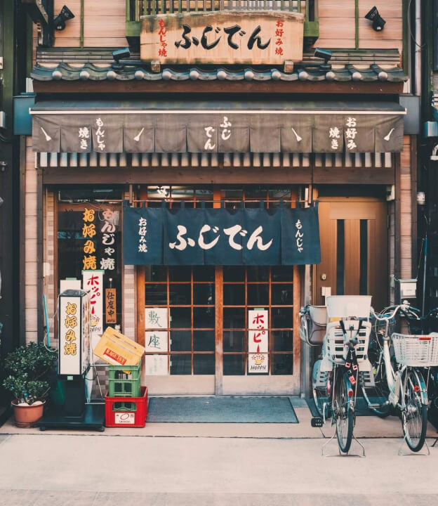 Loja japonesa tradicional com bicicletas estacionadas.